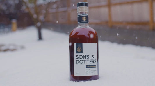 Sons & Dotters Bottled Old Fashioned in the holiday snow outdoors